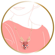 Deer-shaped pendant necklace on a pink background with a gold border